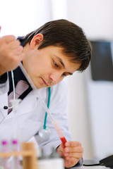 Naklejka premium Researcher working with test tube at cabinet