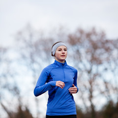 Fototapeta premium Portrait of a woman running against against blue sky