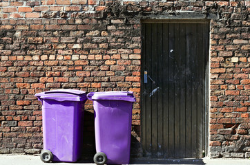 Rufuse bins against old brick wall