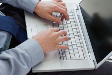 Hands typing on laptop