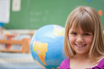 Schoolgirl posing in front of a globe