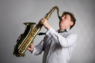 Fototapeta na wymiar Young man plays the saxophone.