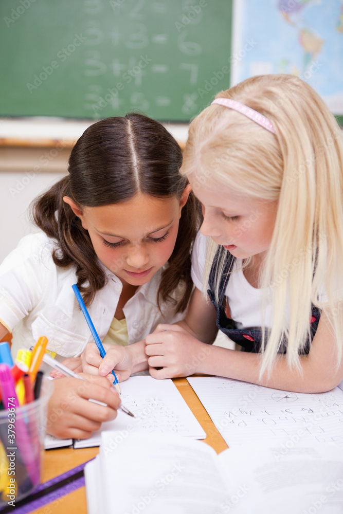 Poster portrait of pupils working together on an assignment