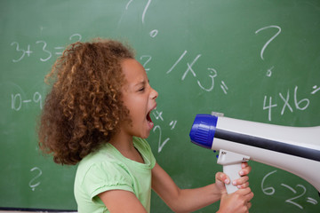 Side view of a schoolgirl screaming through a megaphone