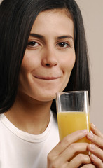 Joven mujer bebiendo jugo de naranja.
