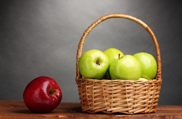 juicy green apples in basket and red apple