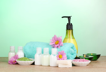 Hotel amenities kit on wooden table on blue background