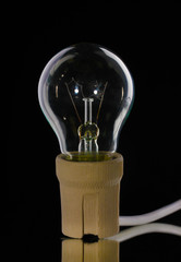 Light bulb in cartridge on black background