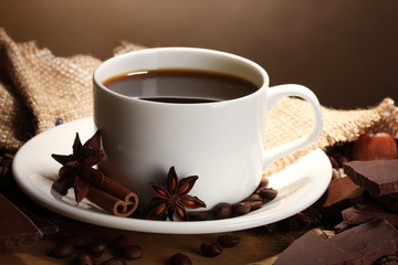 coffee cup and beans, cinnamon sticks, nuts and chocolate