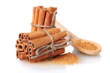 Cinnamon sticks and powder in wooden spoon isolated on white