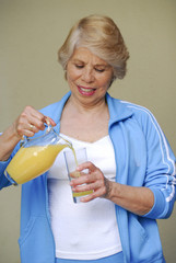 Señora bebiendo jugo de naranja.