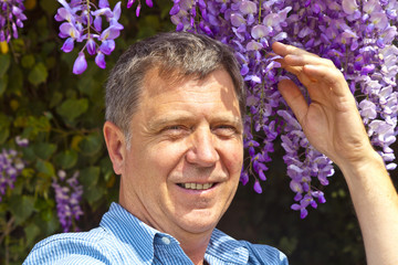attractive man is smelling park flowers