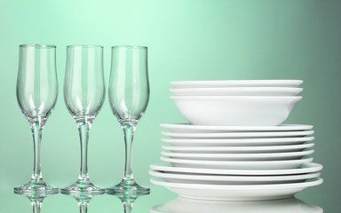 Fototapeta na wymiar Clean plates and glasses on green background