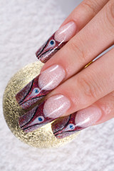 Glamour manicure hand holding gold ball