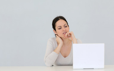 Jeune femme avec ordinateur portable sur fond gris