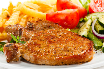 Fried pork chop with French fries and vegetable salad