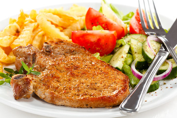 Fried pork chop with French fries and vegetable salad