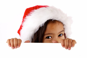 enfant avec des yeux coquins et chapeau de noël