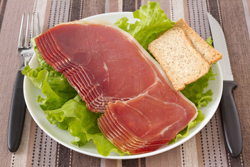 prosciutto with toasts on the plate