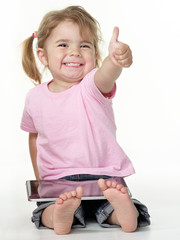 Adorable little girl on the floor playing with touchpad