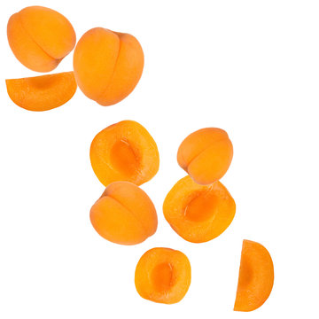 Falling fresh apricots over white background