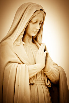 Vintage sepia image of a suffering religious woman praying