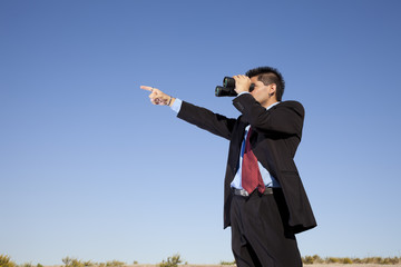 Businessman looking though binoculars