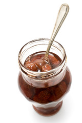 Strawberry jam in jar with silver spoon