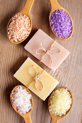 Various types of spa sea salt and soap in wooden spoons closeup