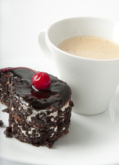 Cup of coffee and chocolate dessert with a cherry