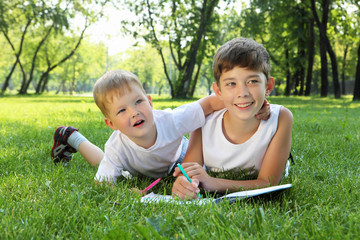 Children in the park reading a book