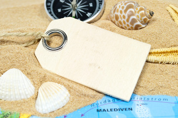 Holzanhänger mit Sand, Muscheln, Seestern und Weltkarte