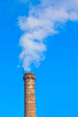 ecology pipe and smoke against the blue sky