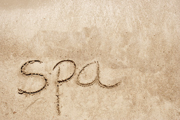 Spa handwritten in sand on a beach