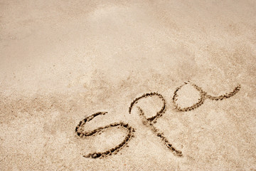 Fototapeta na wymiar Spa handwritten in sand on a beach