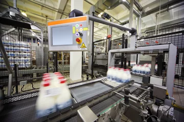 Papier Peint photo Bâtiment industriel Convoyeur avec bouteilles de lait emballées dans une grande usine