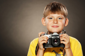 Boy holding an old fashioned camera.