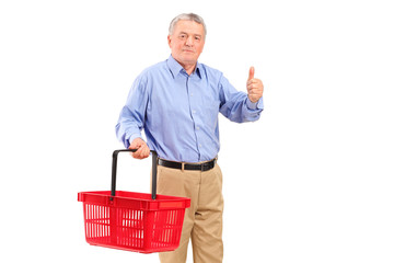 A mature man holding an empty shopping basket and giving thumb u © Ljupco Smokovski