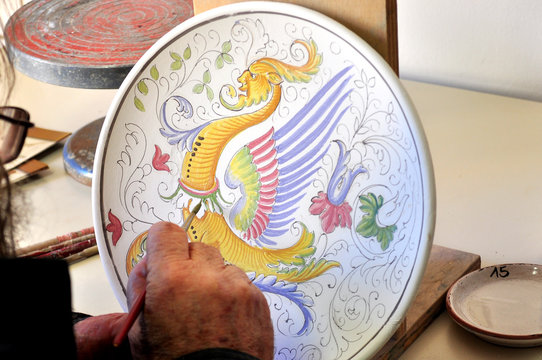 Decorazione a mano di un piatto di ceramica, Deruta Italia