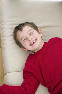 A six years old smiling his eyes squized.