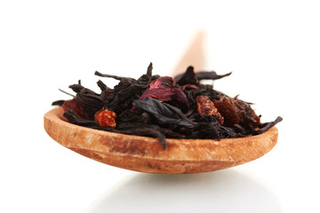 Black fruit dry tea leaves in woooden spoon isolated on white