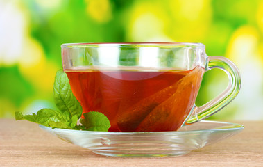 nice cup of tea and mint on green background