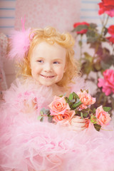 Obraz na płótnie Canvas Girl in the nursery in pink dresses