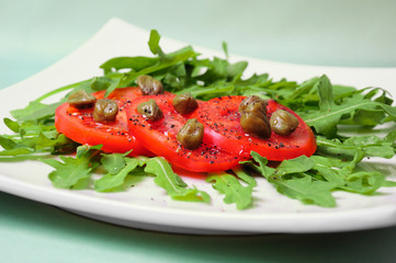 Salad with fresh tomatoes, capers and arugula