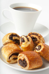 Cup of coffee and small rolls with a poppy