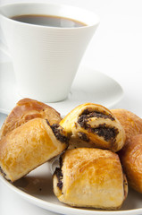 Cup of coffee and small rolls with a poppy