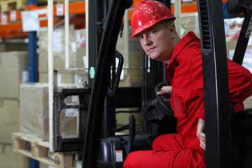 forklift driver worker in red uniform and safety helmet