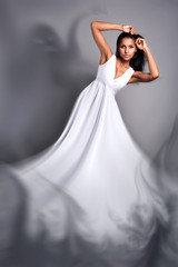Fototapeta premium portrait of a beautiful dark-skinned woman in a white dress