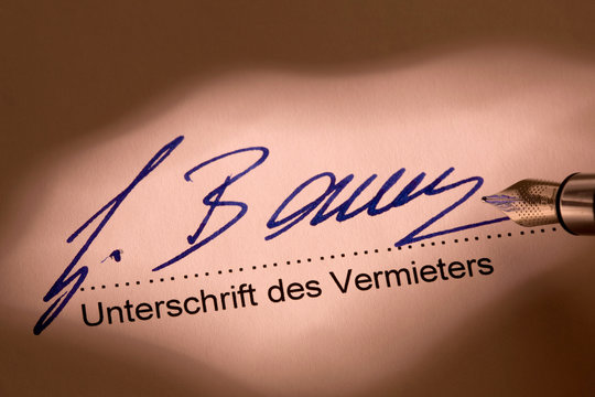 Unterschreiben eines Mietvertrags durch den Vermi