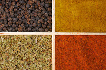 Four spices in a wooden square split jar